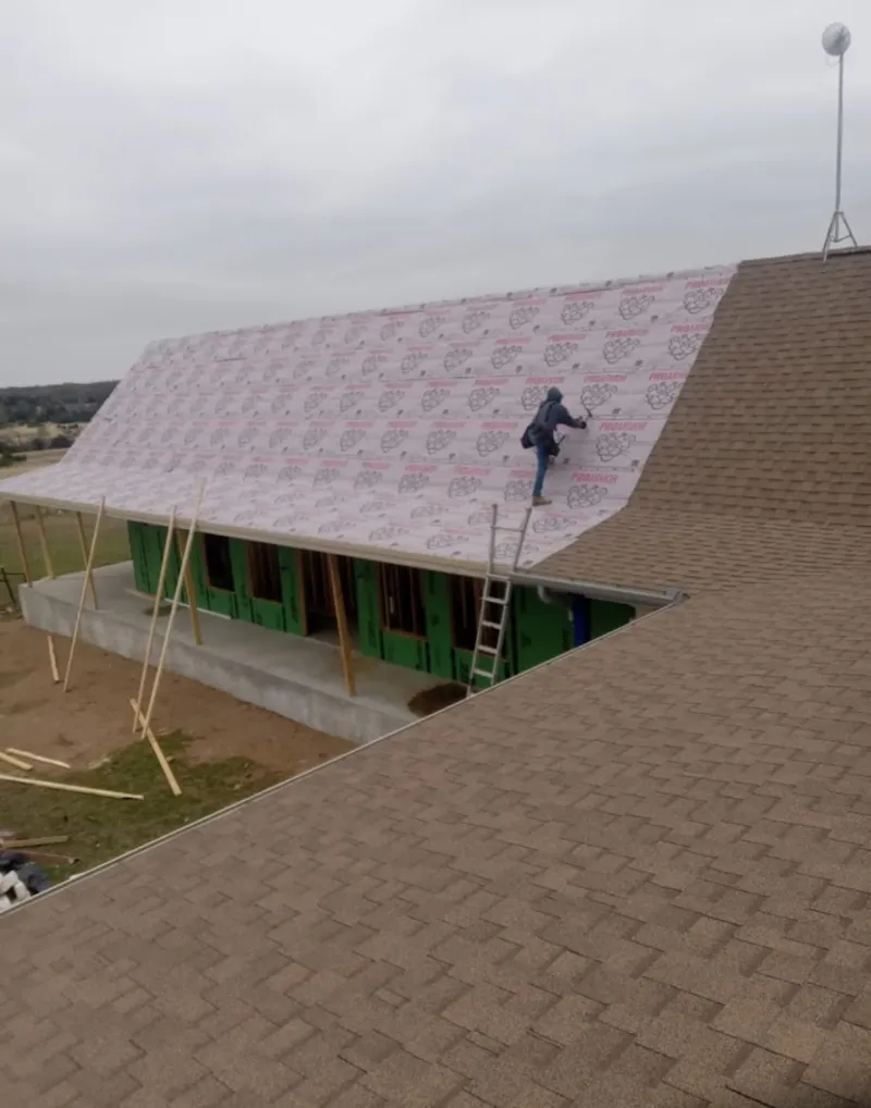 Worker preparing underlayment for a metal roof installation in Inverness Highlands South